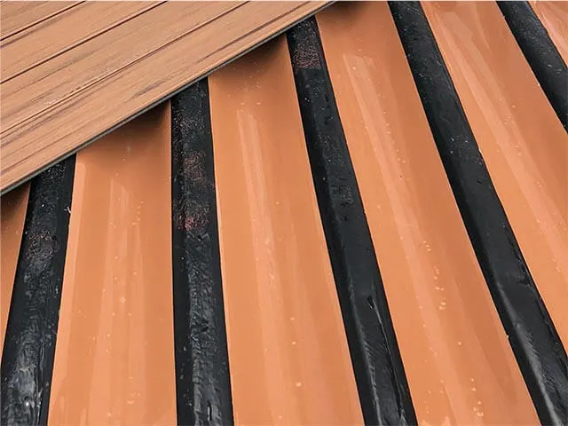 Below-joist aluminum ceiling system on a finished Saskatchewan walkout deck — full waterproof ceiling with integrated lighting, gutter, and pot-light cans